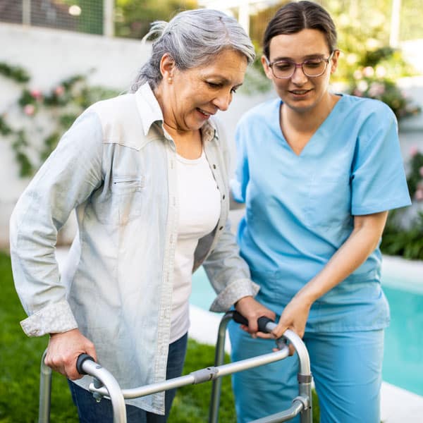 female caregiver assisting woman using a walker