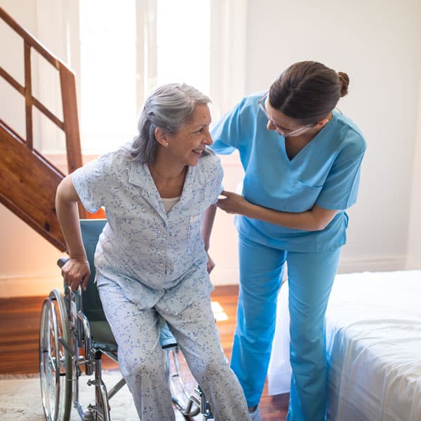 female caregiver helping woman get into a wheelchair